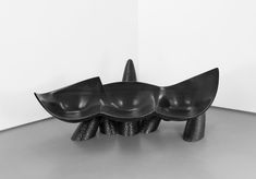 three black bowls sitting on top of each other in the middle of a room with white walls