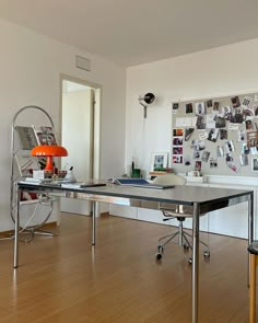 a room with a desk, chair and pictures on the wall