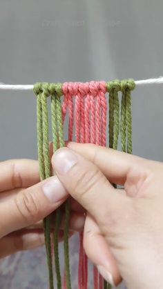 two hands are stitching together with yarn