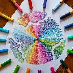 colored crayons are arranged in the shape of a circle on top of white paper