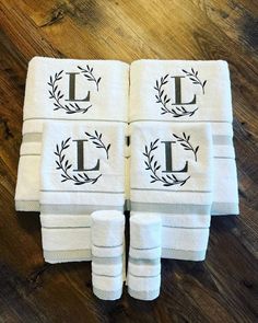 four white towels with the letter e on them sitting on a wooden floor next to each other