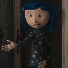 a doll with blue hair and stars on it's body is standing in front of a door