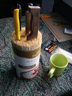 a cup that has some kind of tool in it on top of a table next to other items