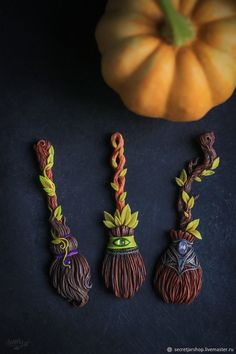 three halloween decorations are sitting on a table next to a small pumpkin and a broom