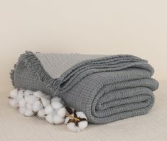 a pile of cotton sitting on top of a bed next to a blanket and pillow