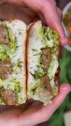 two hands holding a sandwich with meat and broccoli