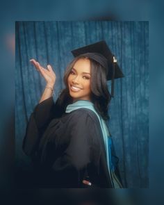 a woman wearing a graduation cap and gown waving to the camera with her hand in the air