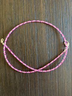 pink and white beaded bracelet on wooden table