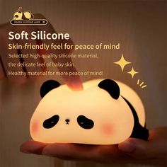 a person holding a small lamp with a panda bear on it's face and the caption soft silcone skin - friendly feel for peace of mind