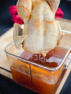 a raw chicken in a plastic container with ketchup