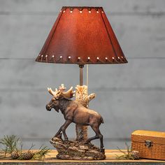 the moose lamp is next to an old suitcase and a christmas tree ornament