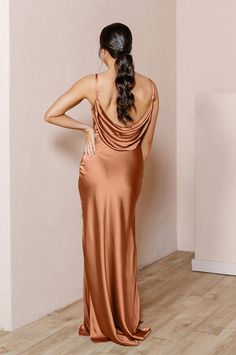 a woman in a gold dress looking back