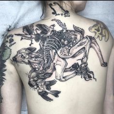 the back of a woman's body with tattoos on it