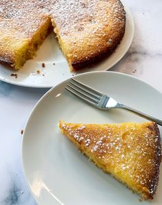 a piece of cake on a white plate with a fork next to it and another slice missing