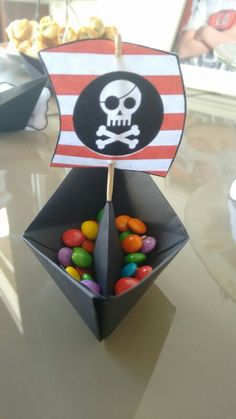 a pirate flag made out of candy in a box on a table with other candies