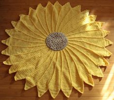 a large yellow flower rug on top of a wooden floor