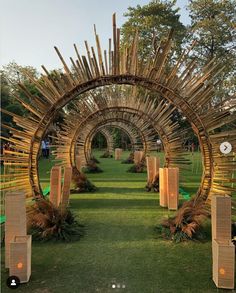 an arch made out of bamboo sticks in the grass