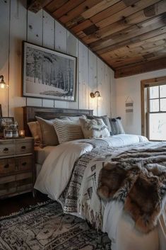 a large bed sitting under a window next to a wooden ceiling with two lamps on each side