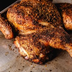 a close up of some chicken on a pan with seasoning sprinkles