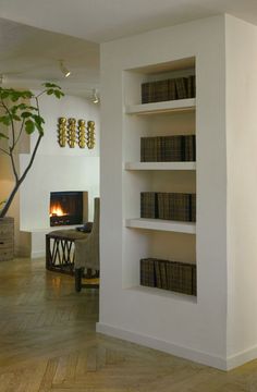 a living room filled with furniture and a fire place in the middle of it's wall