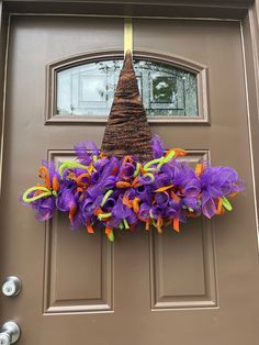 a purple and orange wreath hanging on the front door