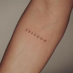 a person's arm with the word freedom written on it in cursive font