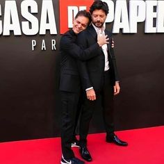 two men in suits hugging each other on the red carpet at the movie premiere for la casa de papela