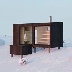 an outdoor sauna in the snow on a sunny day