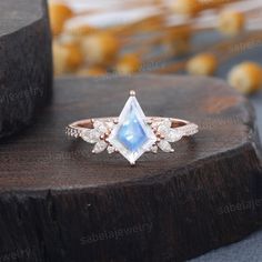 an engagement ring with a pear shaped blue topazte surrounded by small white diamonds