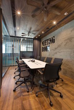 a meeting room with black chairs and a white table in front of a wall that says meeting room