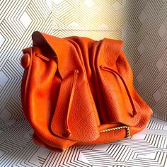 Some Discoloration See Photos Textured Leather Bucket Bag In Pouch Shape For Everyday, Designer Leather Shoulder Pouch, Designer Soft Leather Bucket Bag Pouch, Designer Soft Leather Pouch Bucket Bag, Leather Pouch For Shopping, Chic Orange Leather Shoulder Bag, Luxury Bucket Pouch For Everyday Use, Orange Top Handle Shoulder Bag With Dust Bag, Luxury Bucket Pouch For Daily Use