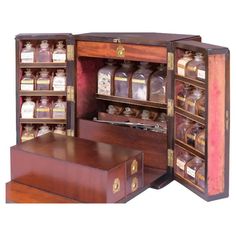 an open wooden cabinet with many bottles in it's shelves and drawers on the inside