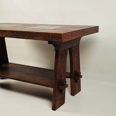 a wooden table with glass top and shelf on the bottom, against a white background