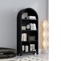 a black book shelf with books on it in a living room next to a white rug