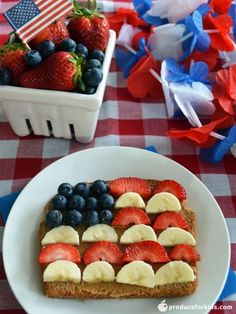 a piece of bread with fruit on it and an american flag cut in half sitting on a table