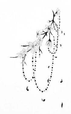 a black and white photo of flowers on a branch with beads hanging from it's end