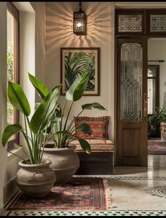 a living room with potted plants and pictures on the wall next to it's doorway