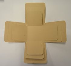 four pieces of tan colored paper are arranged in the shape of a cross on a white background