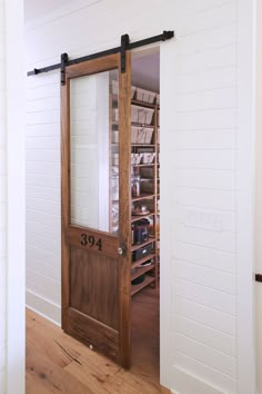 an open door to a pantry in a room with white walls and wood floors,