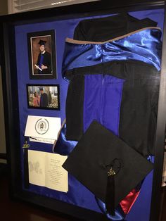 a display case with blue and black items in it, including a graduation cap and gown