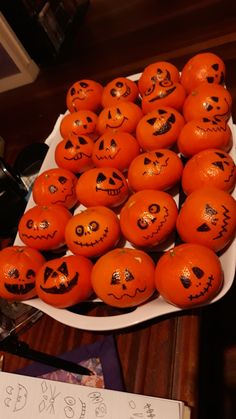 a plate full of pumpkins with faces drawn on them