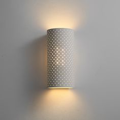 a wall mounted light that is on the side of a wall with polka dot pattern