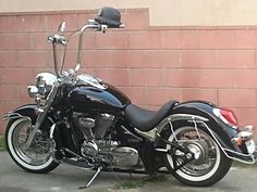 a black motorcycle parked in front of a brick wall