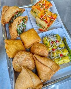 several different types of pastries on a tray with silver table cloth and metal surface