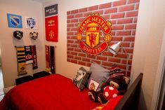 a bedroom with a brick wall and manchester united emblem on the wall above the bed