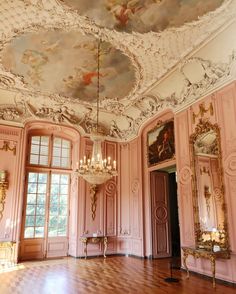 an ornately decorated room with chandeliers and paintings on the walls, painted in pink