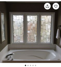 a bath tub sitting next to a window in a bathroom