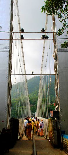 several people are standing on the bridge