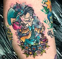 a woman's leg with tattoos on it and an image of a cartoon character