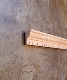 a wooden ruler mounted to the side of a wall